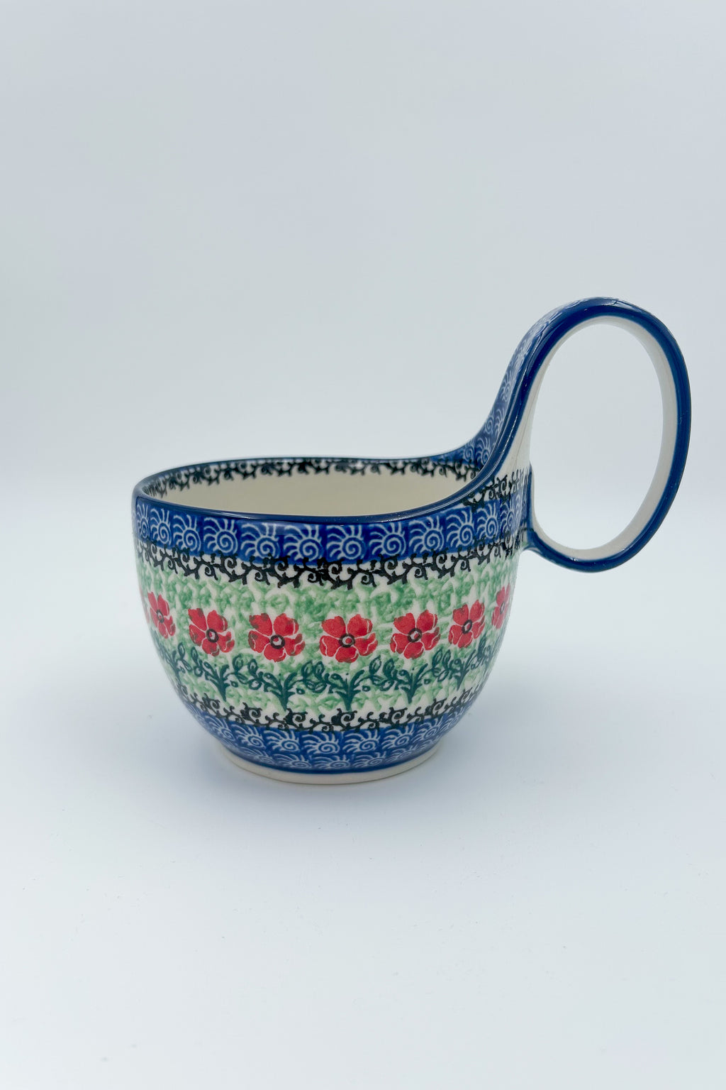 Maraschino loop-handle bowl, straight-on front view with plant in background