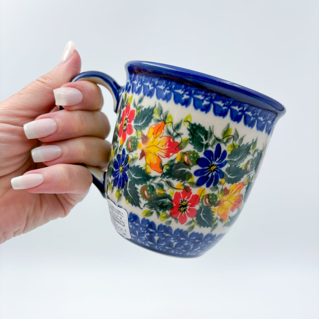 Fall Colors Viking mug held in hand, front view showing autumn floral pattern