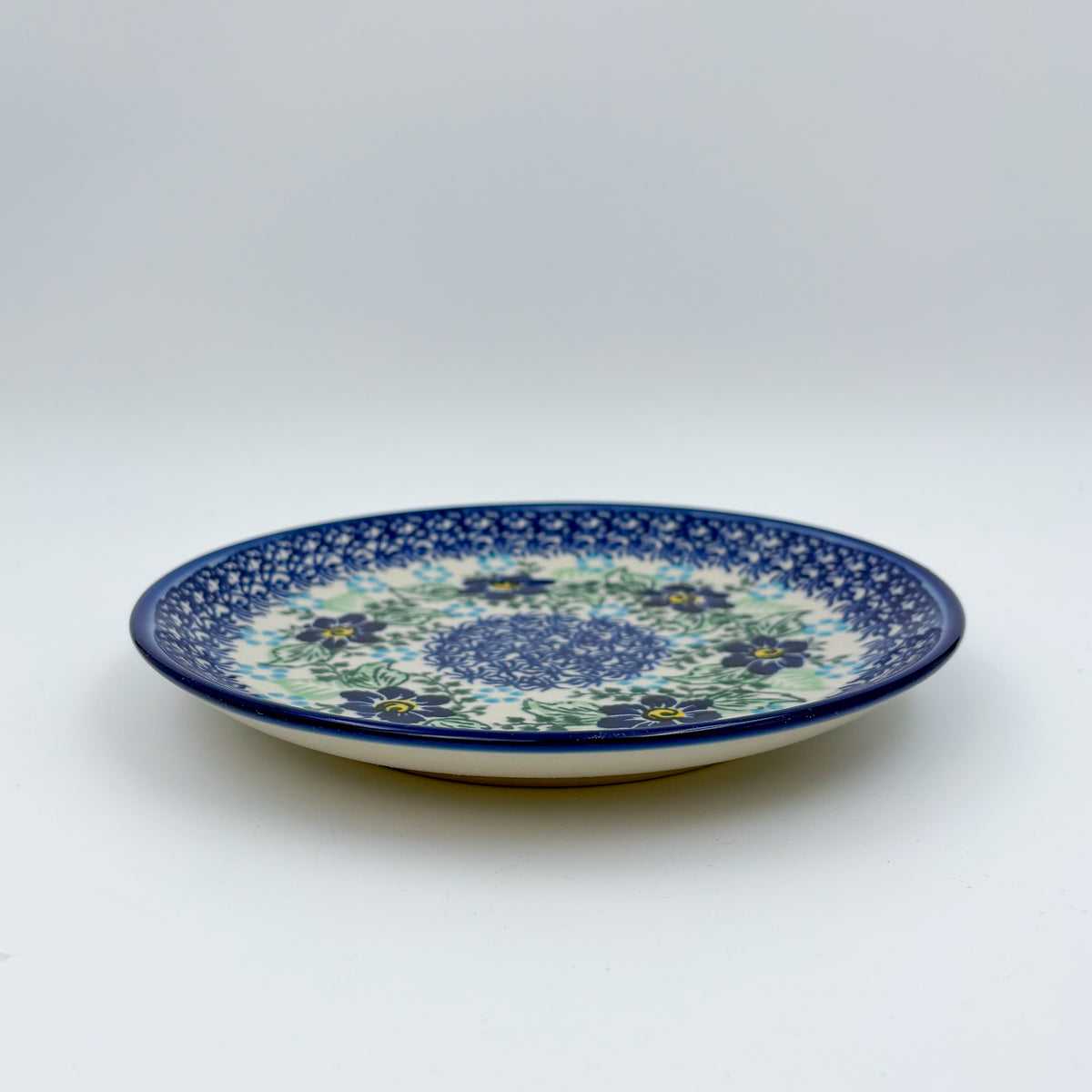 UNIKAT Blue Floral Day plate, front view showing blue flower ring and mosaic center on scalloped rim
