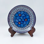 UNIKAT Cobalt Poppies dessert plate, front view displayed on wooden stand showing blue poppy cluster