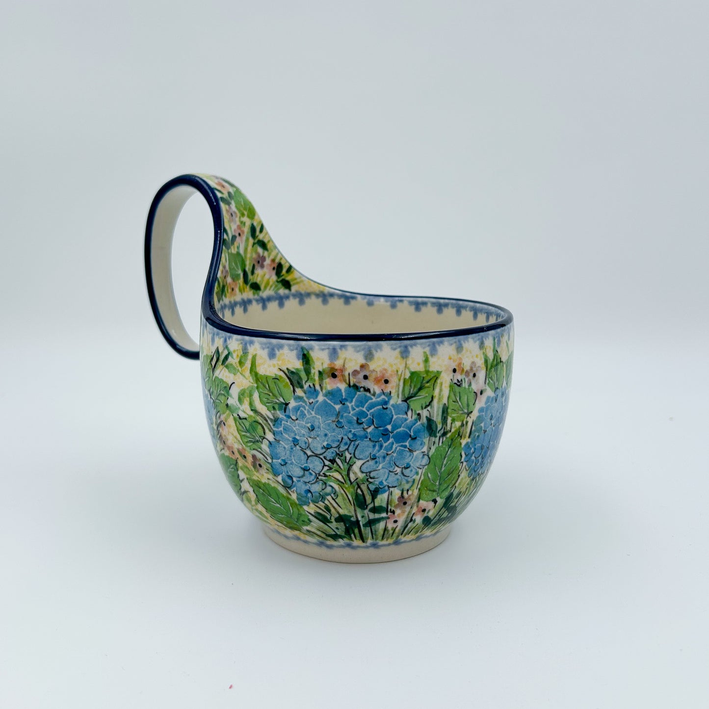 Polish pottery 16oz bowl with loop handle in the UNIKAT Blue Hydrangea pattern. This Polish Pottery bowl is made by talented artisans from Poland. 
6.26" x 4.49" x 5.51"
Ceramika Artystyczna Company