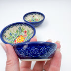 Ladybug Fields stacking bowl set held in hand, three bowls nested at different depths