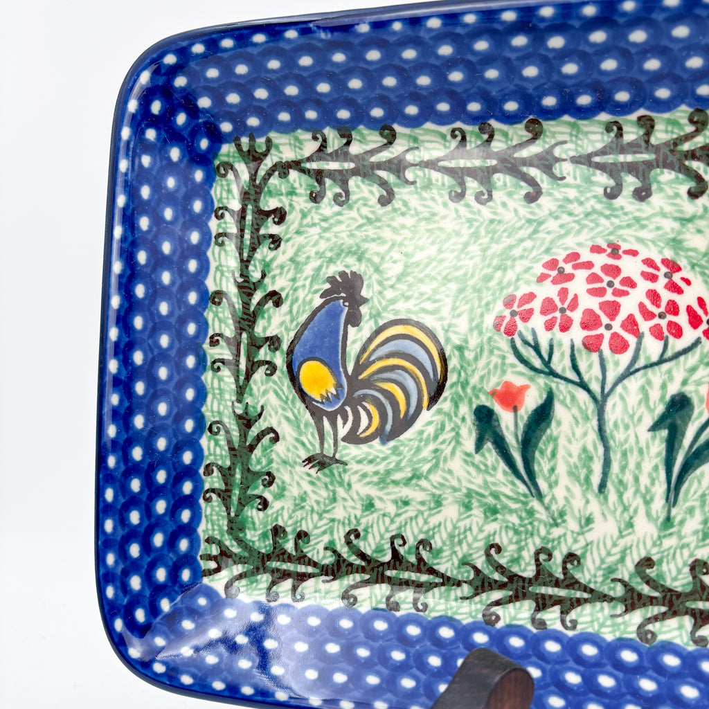 UNIKAT Rooster Dance rectangular platter, corner close-up view of rooster and pom-pom flower on polka-dot border