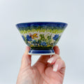 Bluebell Meadow small pedestal bowl held in hand showing blue florals and butterfly on green meadow band