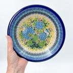 UNIKAT Blue Hydrangea pasta bowl, top-down view held in hand showing hydrangea bouquet and blue rim