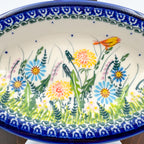 UNIKAT Songbird Garden oval Milano platter, close-up top-down view of dandelions, blue daisies, and yellow songbird