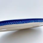 UNIKAT Blueberry oval tray, low-angle exterior side view showing mosaic center band and plain rim