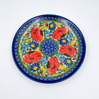 UNIKAT Garden Poppy plate, top-down view of full plate showing red poppy ring and blue spiral center