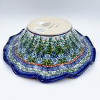 Angled view of Whispering Ferns wave bowl showing bottom stamp and exterior pattern