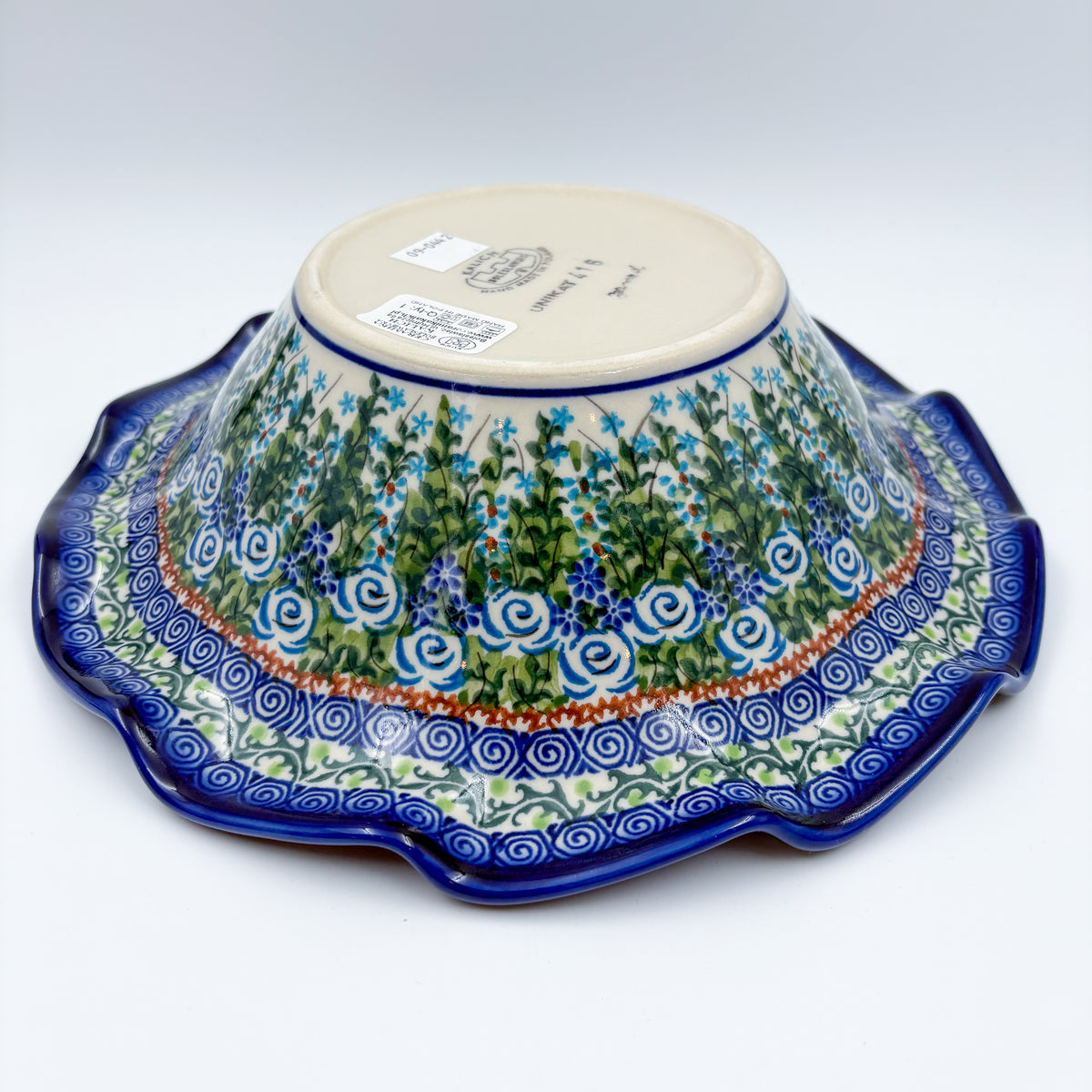 Angled view of Whispering Ferns wave bowl showing bottom stamp and exterior pattern