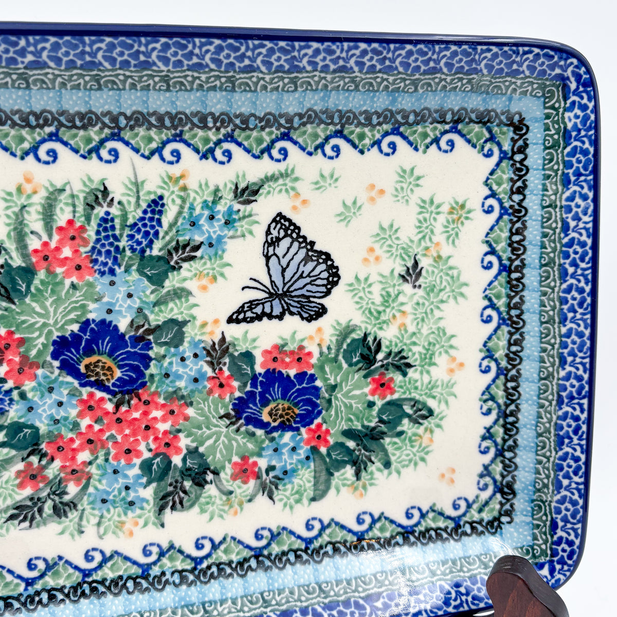 Mariposa rectangular platter, close-up rim detail showing layered floral border above butterfly and bouquet