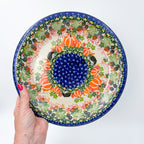 UNIKAT Hedgehog and Pumpkins plate held in hand, top-down view showing pumpkins, hedgehogs, and berry border