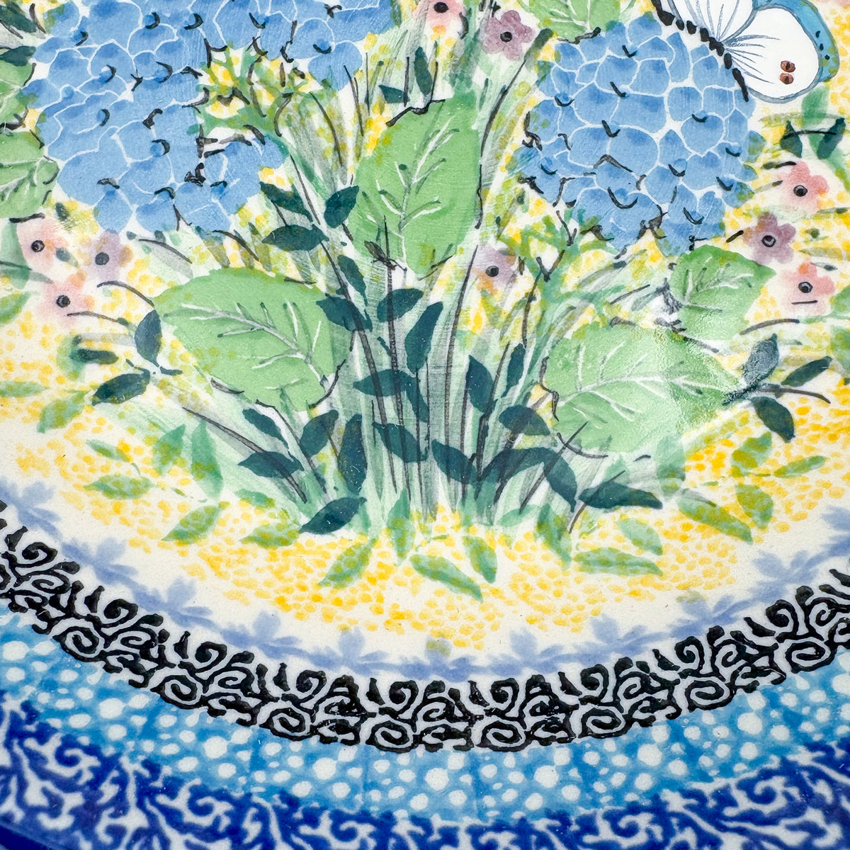 UNIKAT Blue Hydrangea pasta bowl, close-up top view of leaves and pink accent flowers