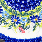 UNIKAT Meadow Breeze plate, close-up rim detail showing blue wildflowers and red accent flowers