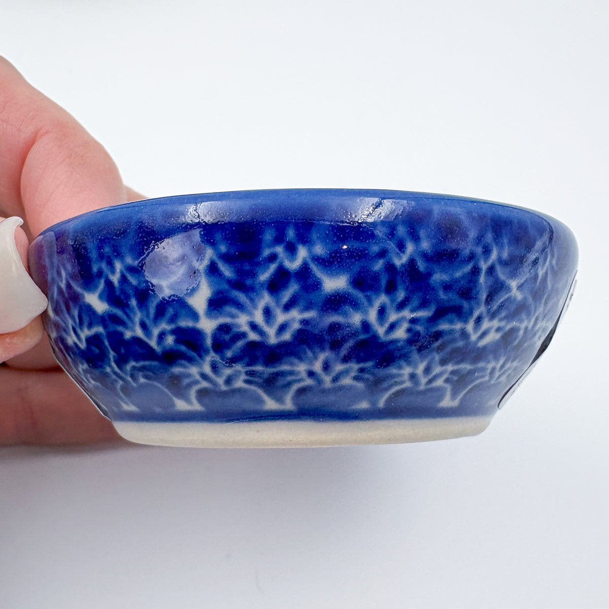 UNIKAT Orange Poppy small stacking bowl set, exterior side view of medium bowl showing blue lace rim