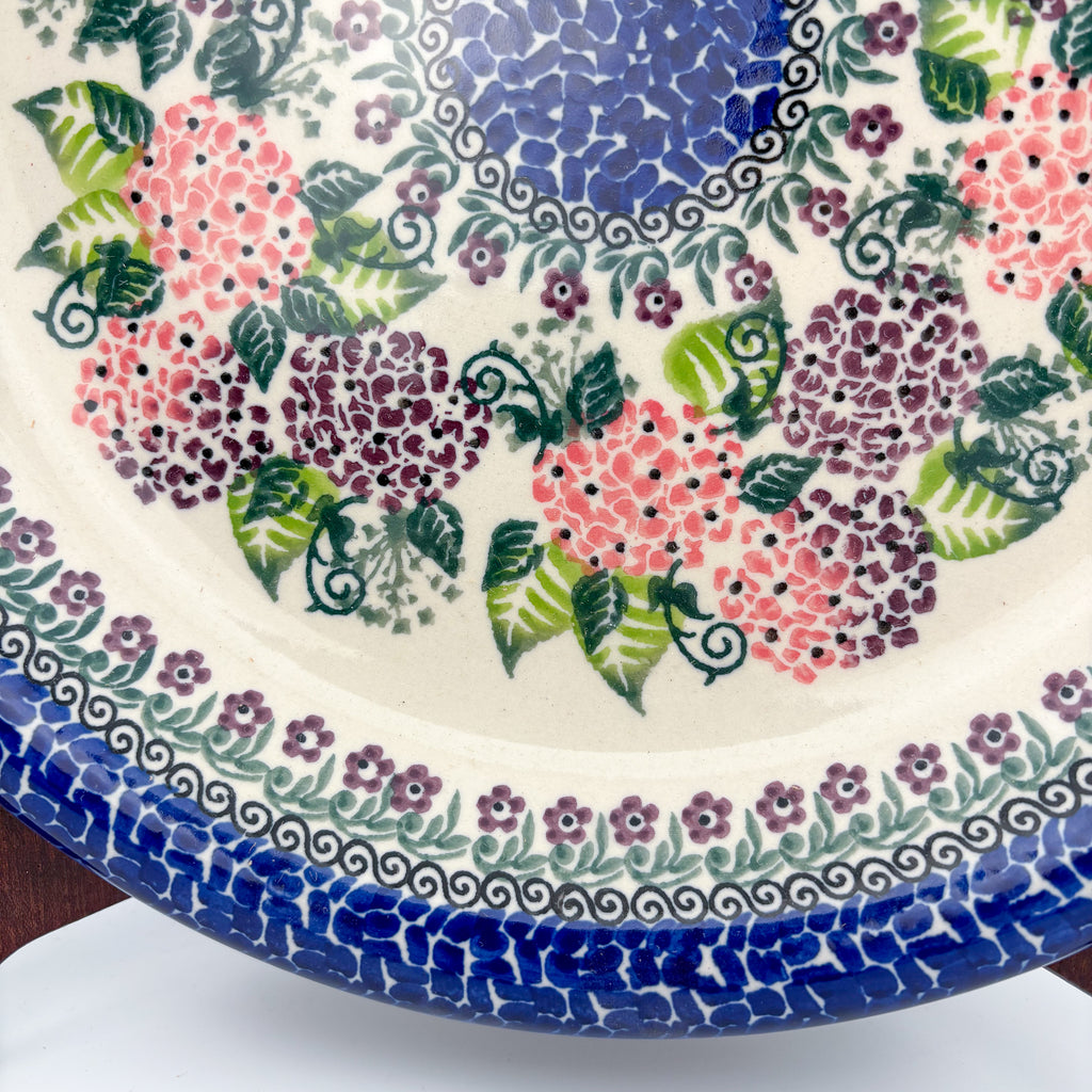 UNIKAT Happy Hydrangea plate, close-up rim view showing hydrangea clusters and blue mosaic rim