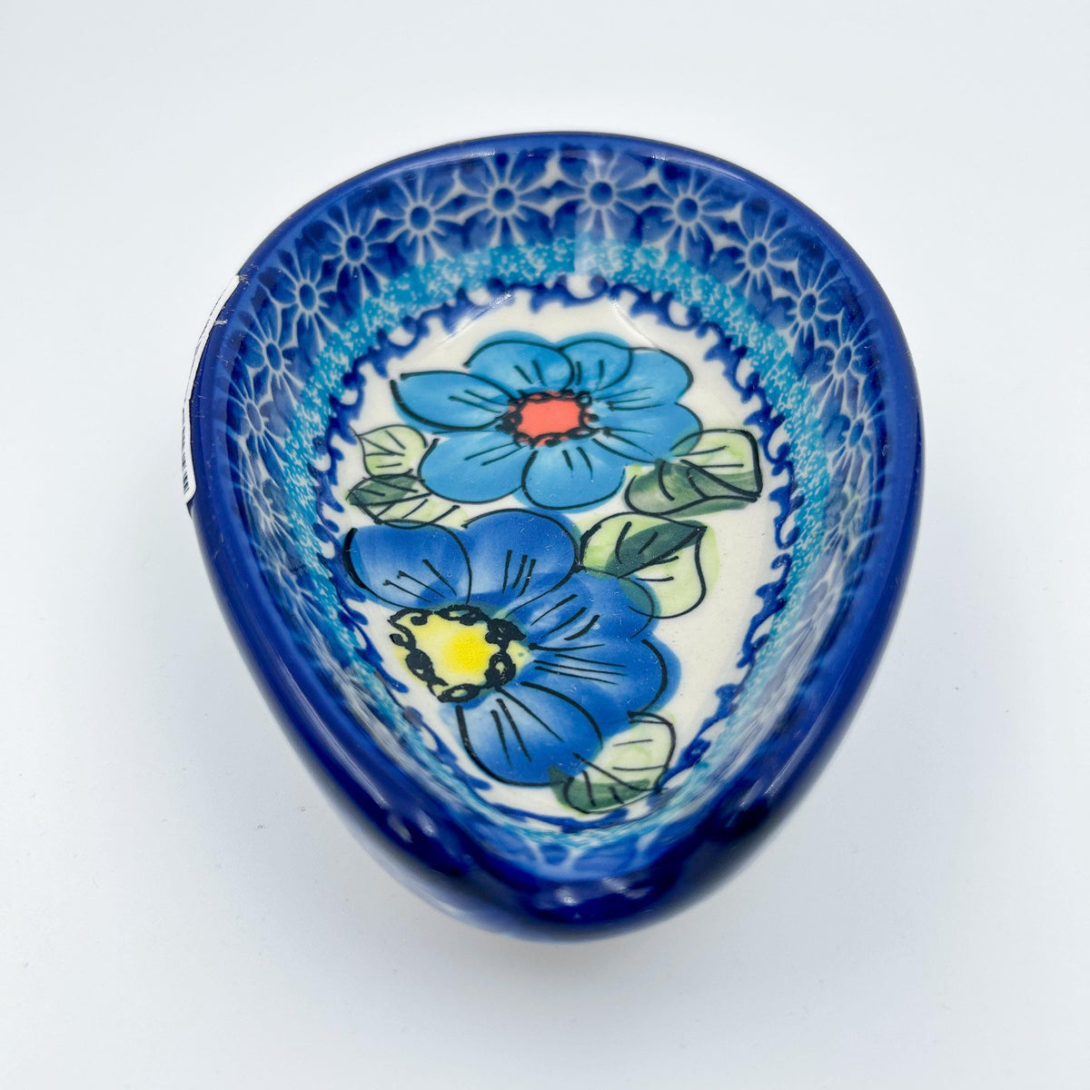 This 5” blue floral spoon rest is a handmade by talented Polish artisans. This is a Polish UNIKAT Bold Blue Poppies pattern 
Dimensions 5” x 3.54"
Ceramika BonaCompany