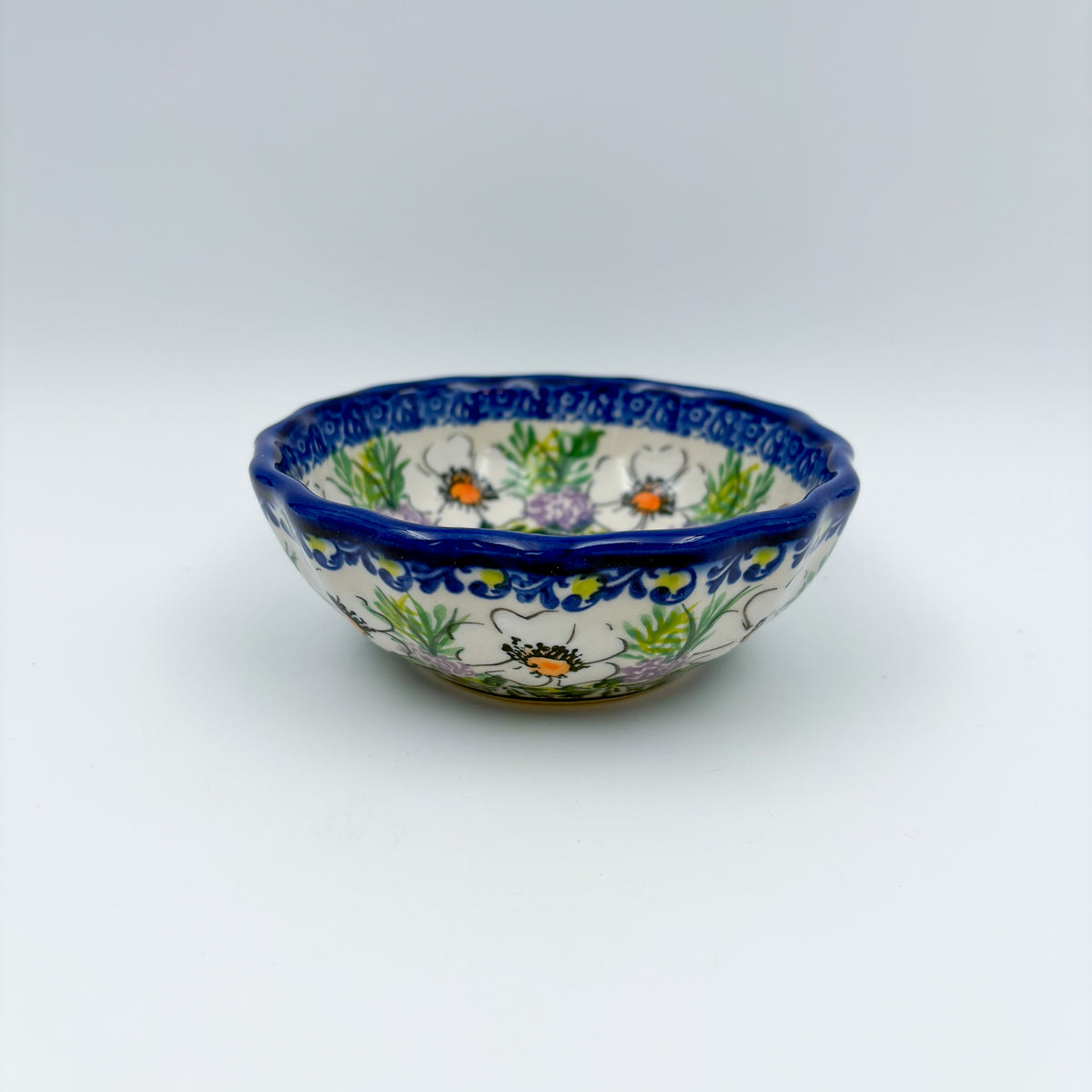 UNIKAT Primrose scalloped bowl, front view showing white poppies and lavender florals on scalloped rim