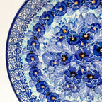 UNIKAT Deep Winter plate, close-up rim detail showing rose border and blue pansy petals