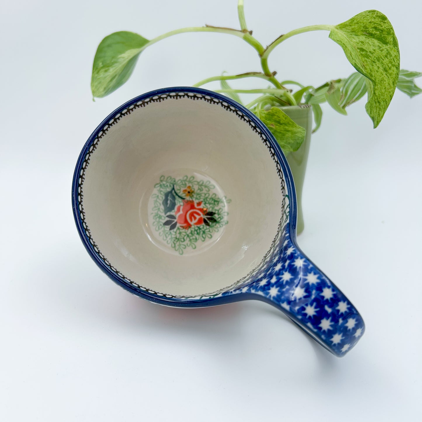 Polish pottery 16oz floral bowl with loop handle in the UNIKAT Sweet Leilani pattern. This Polish Pottery bowl is made by talented artisans from Poland.  16 oz of fluid.
6.26" x 4.49" x 5.51"
Ceramika Artystyczna Company