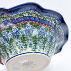 Angled bottom stamp view of Whispering Ferns wave bowl, held in hand