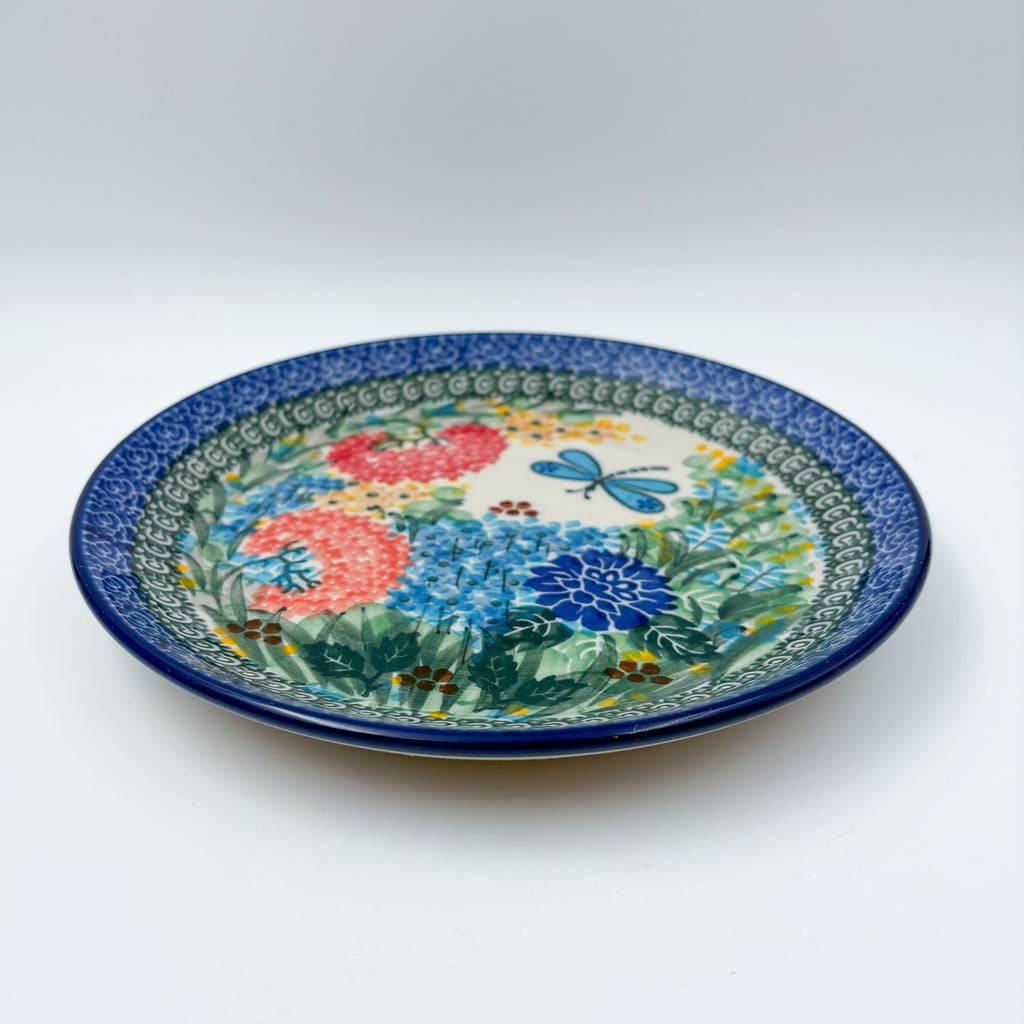 UNIKAT Garden Delight plate, front view showing pom-pom flowers, dahlia, and dragonfly on scalloped border