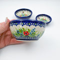 Ladybug Fields stacking bowl set held in hand, largest bowl with two smaller bowls behind