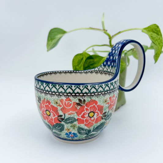 Polish pottery 16oz floral bowl with loop handle in the UNIKAT Sweet Leilani pattern. This Polish Pottery bowl is made by talented artisans from Poland.  16 oz of fluid.
6.26" x 4.49" x 5.51"
Ceramika Artystyczna Company