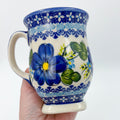 Blue Poppy tulip mug held in hand, front view