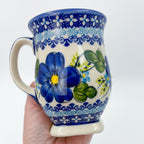 Blue Poppy tulip mug held in hand, front view