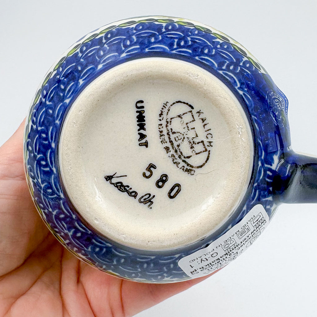 Bottom of Fall Sunflower bubble mug showing Unikat stamp and artist signature, held in hand