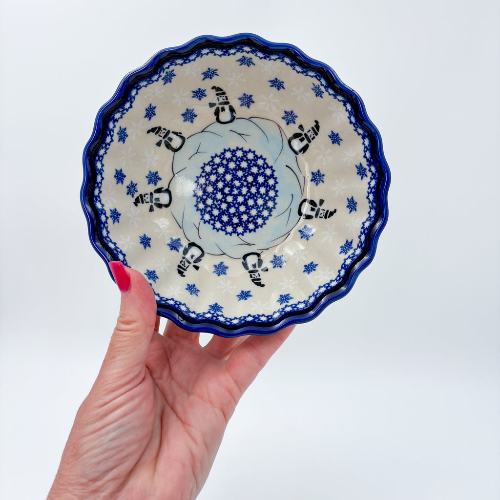 Snowman Penguins Design shell bowl, top-down view held in hand showing snowman figures and snowflakes