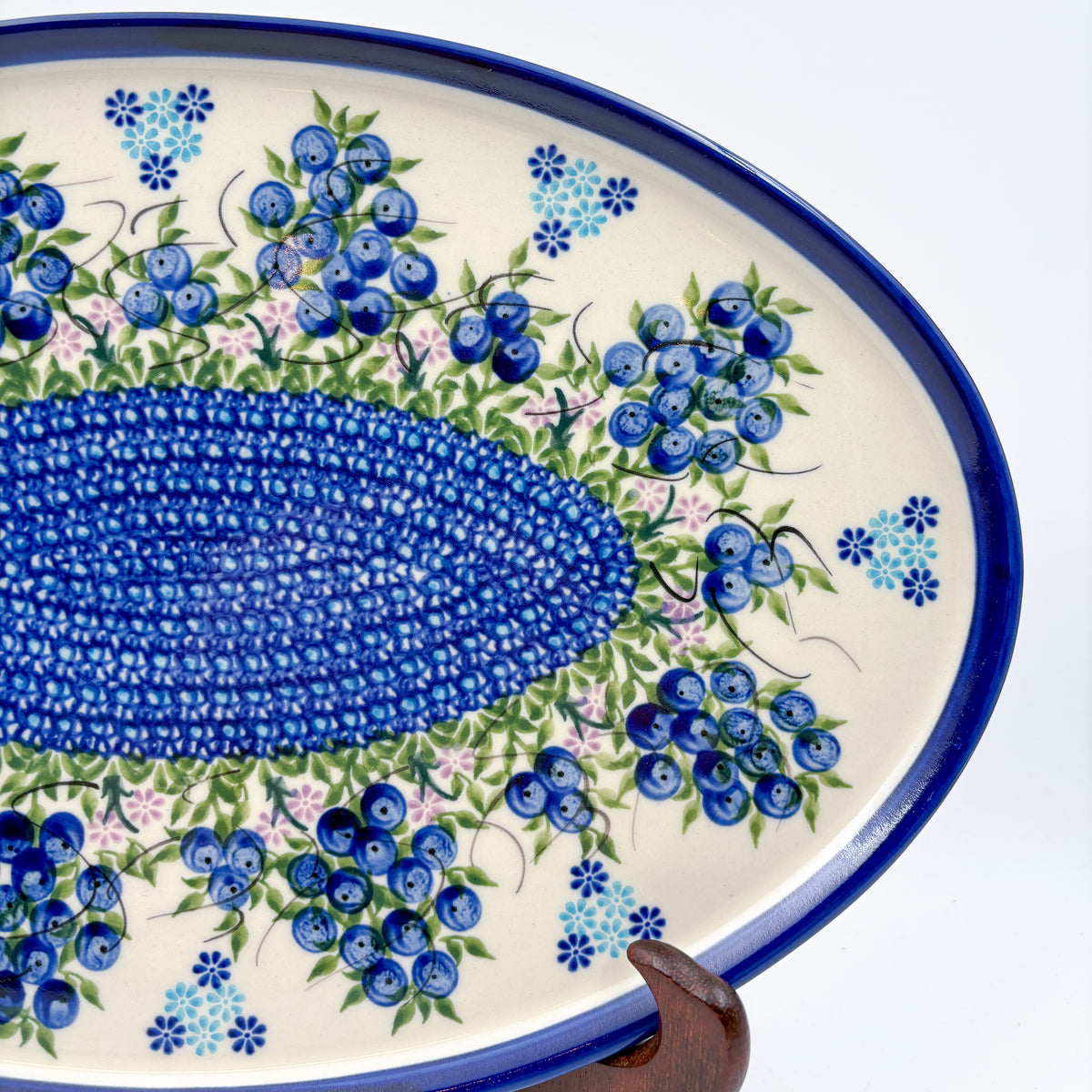 UNIKAT Blueberry oval tray, angled view of mosaic center band and blueberry clusters displayed on stand