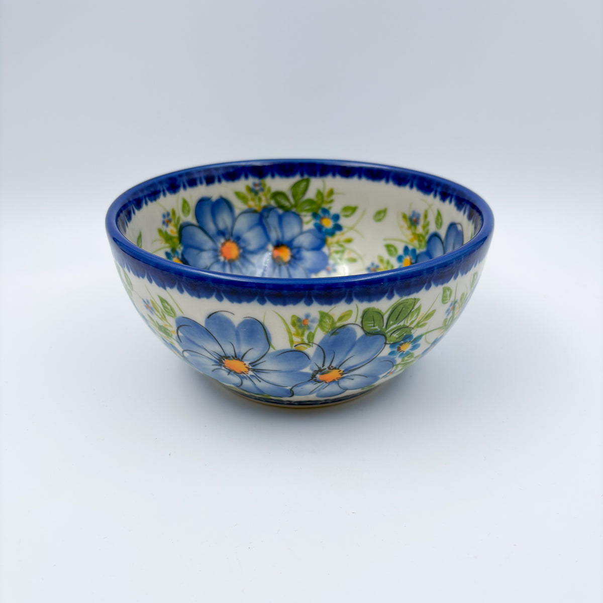Blue Daisy bowl, front view showing large blue daisy flowers on cream background
