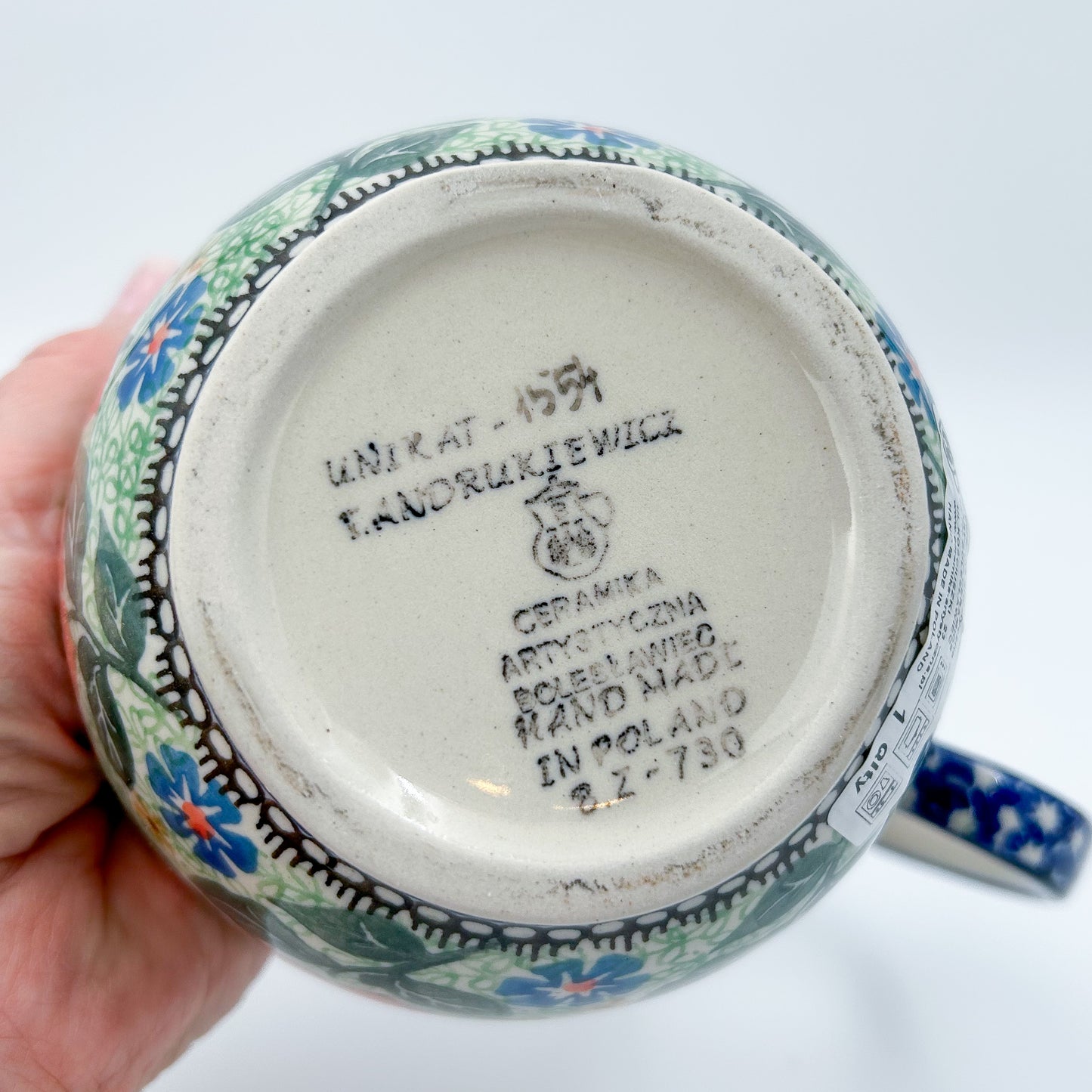 Polish pottery 16oz floral bowl with loop handle in the UNIKAT Sweet Leilani pattern. This Polish Pottery bowl is made by talented artisans from Poland.  16 oz of fluid.
6.26" x 4.49" x 5.51"
Ceramika Artystyczna Company