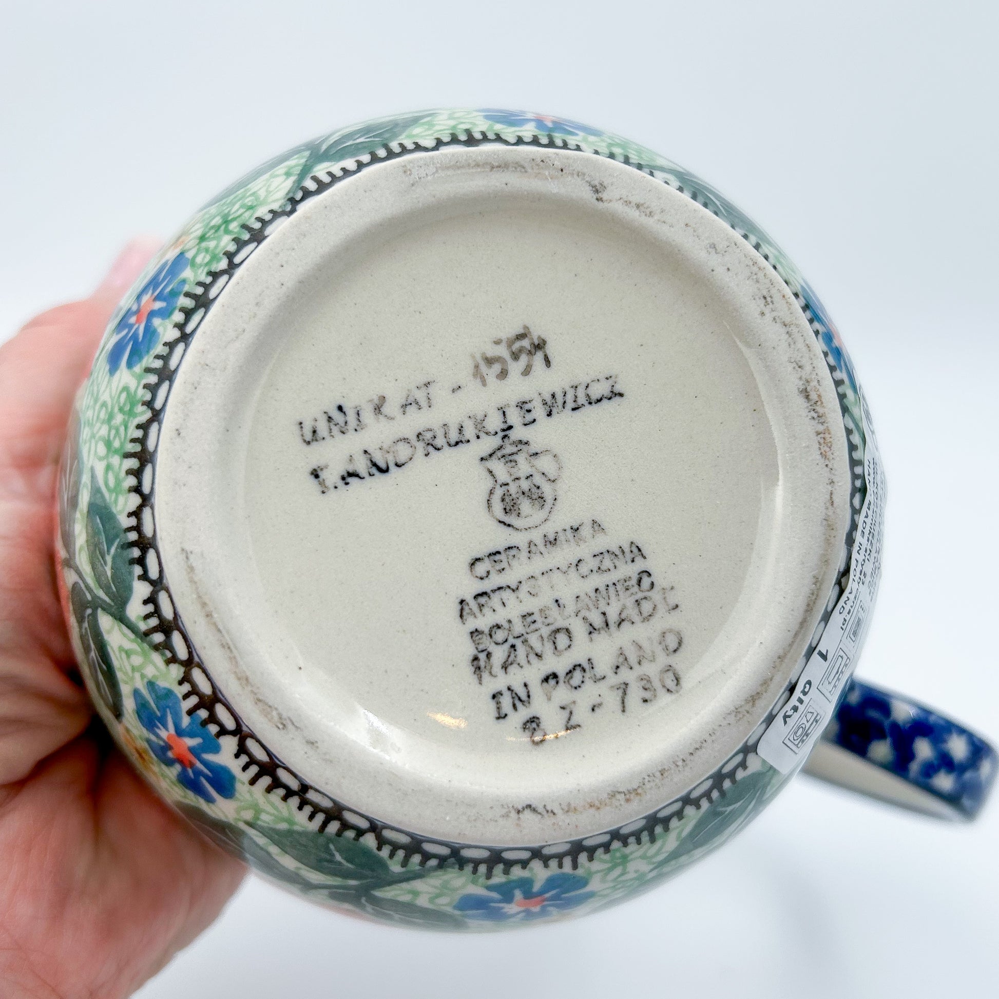 Polish pottery 16oz floral bowl with loop handle in the UNIKAT Sweet Leilani pattern. This Polish Pottery bowl is made by talented artisans from Poland.  16 oz of fluid.
6.26" x 4.49" x 5.51"
Ceramika Artystyczna Company