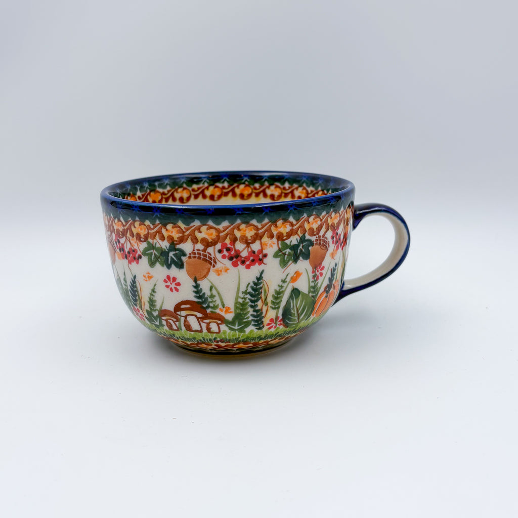 Hedgehog and Acorns latte mug on white background, straight-on view with handle