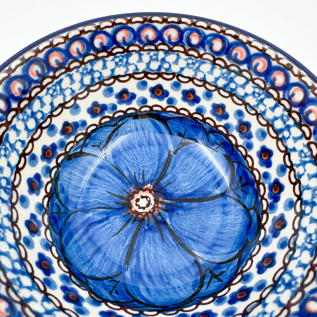 UNIKAT Cobalt Poppies bowl, close-up exterior view of peacock feather scale pattern near bottom stamp