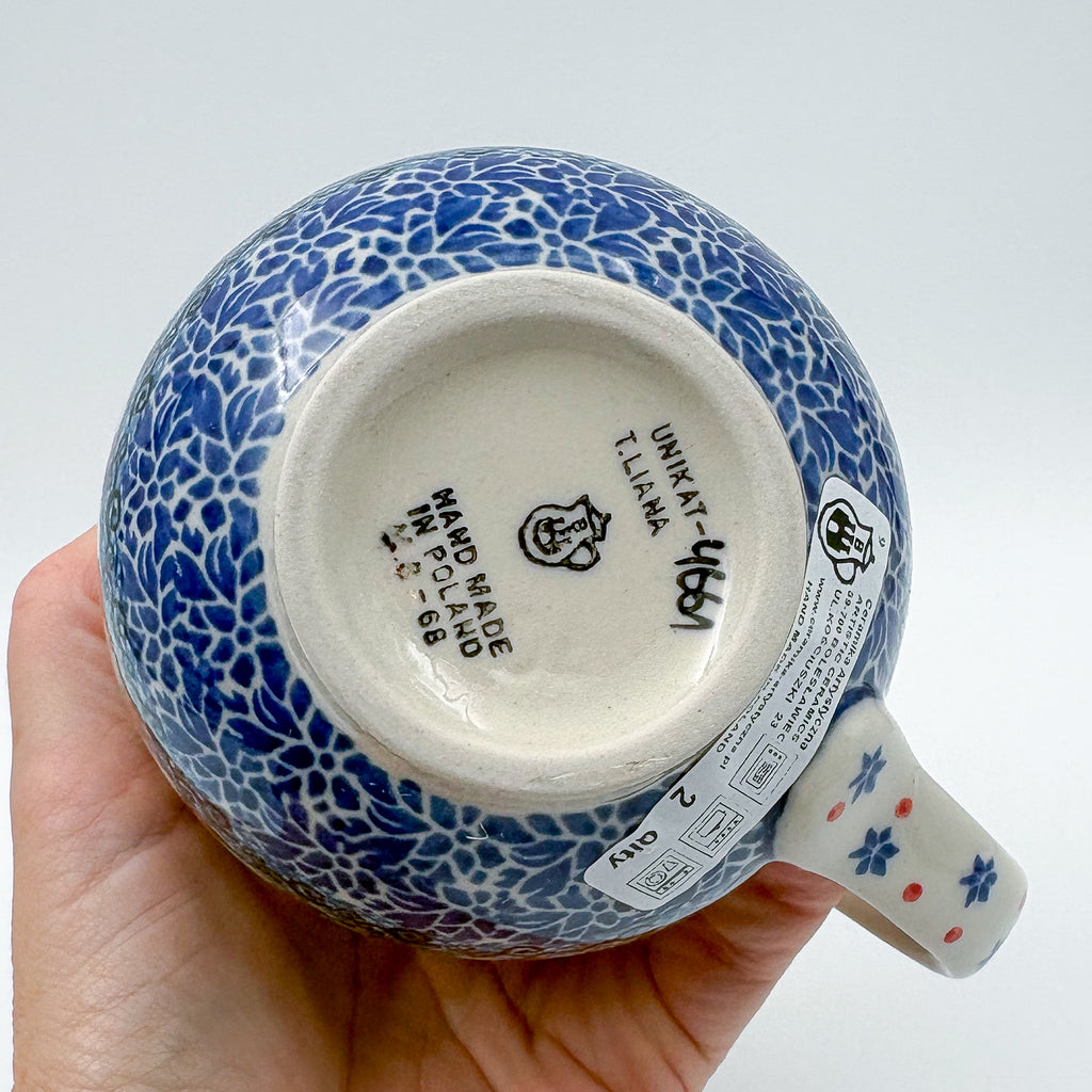 Bottom of Snowman Stroll bubble mug showing Unikat stamp and artist signature, held in hand