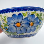 Blue Daisy bowl, close-up exterior view held in hand showing blue daisy flowers and leaves