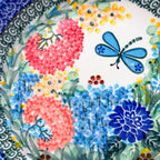 UNIKAT Garden Delight plate, close-up view of coral pom-pom flowers and blue dragonfly