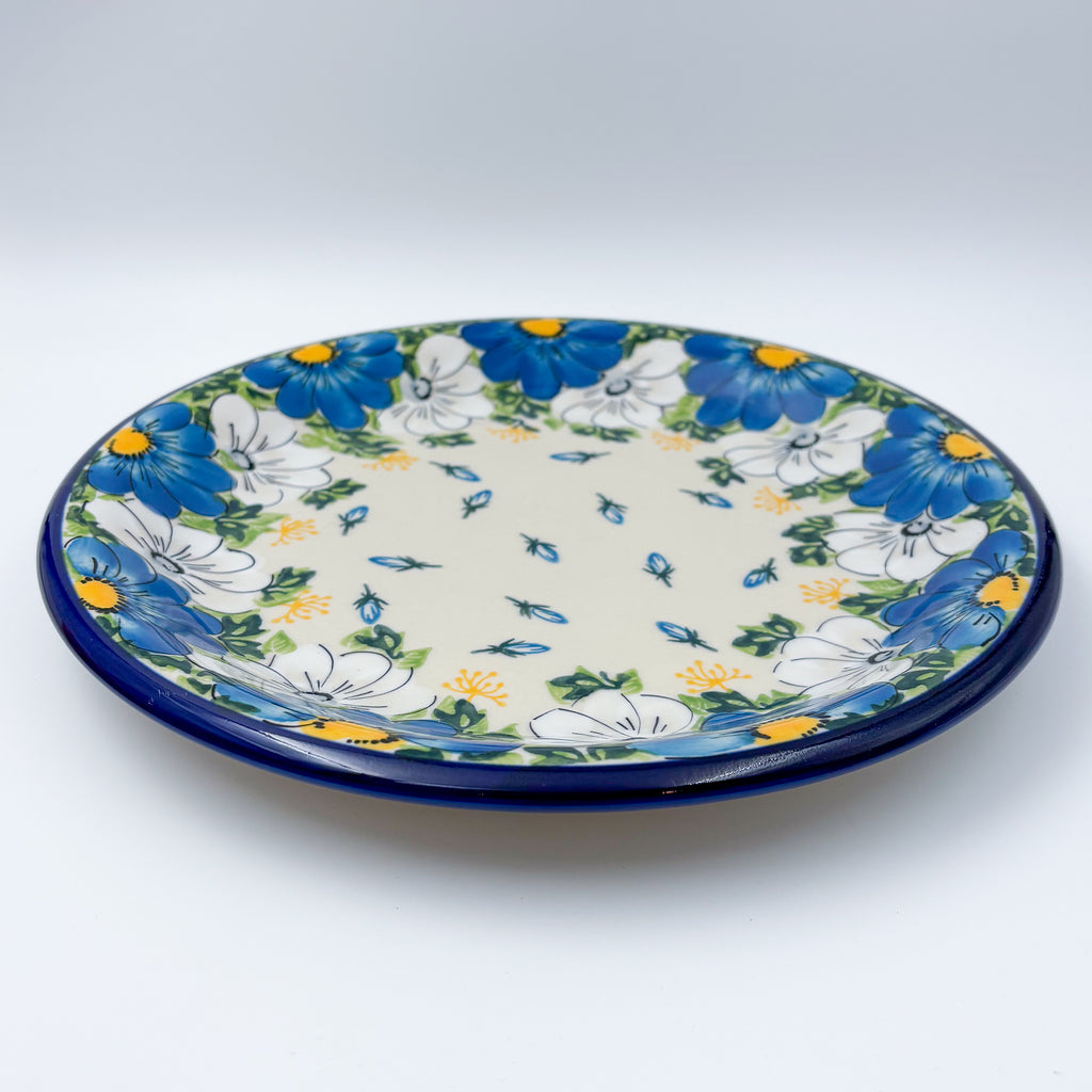UNIKAT Blue Petal Dance plate, front view showing blue and white daisy ring on scalloped rim