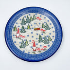UNIKAT Gnome Village plate, top-down view showing two gnomes, snowy cabin, and pine trees scene