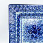 UNIKAT Deep Winter square plate, close-up corner view of blue pansy bouquet and rose border pattern