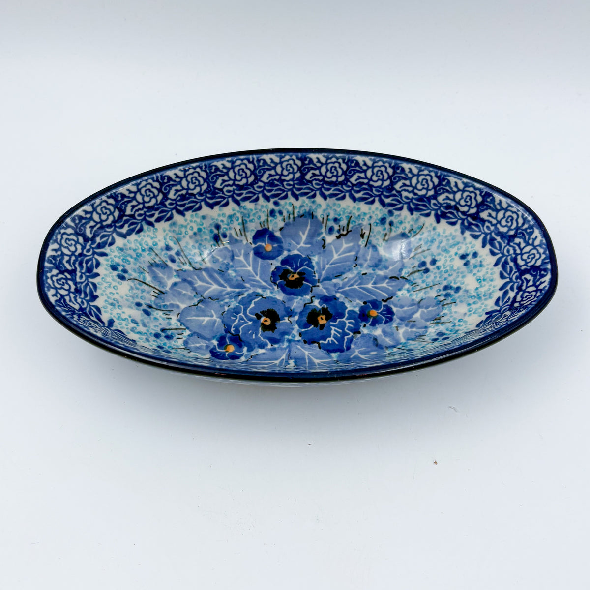 UNIKAT Deep Winter oval bowl, front view showing blue pansy bouquet with rose border