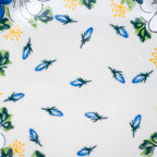 UNIKAT Blue Petal Dance plate, close-up top-down view of scattered blue petal accents on cream center