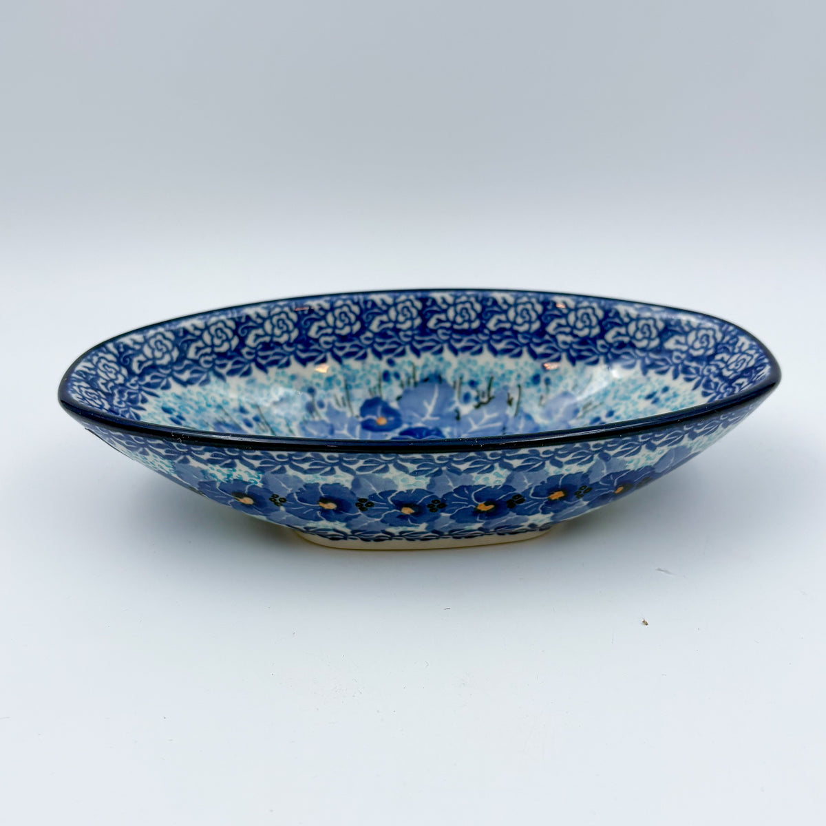 UNIKAT Deep Winter oval bowl, front view on oval foot showing blue pansy pattern and floral rim band