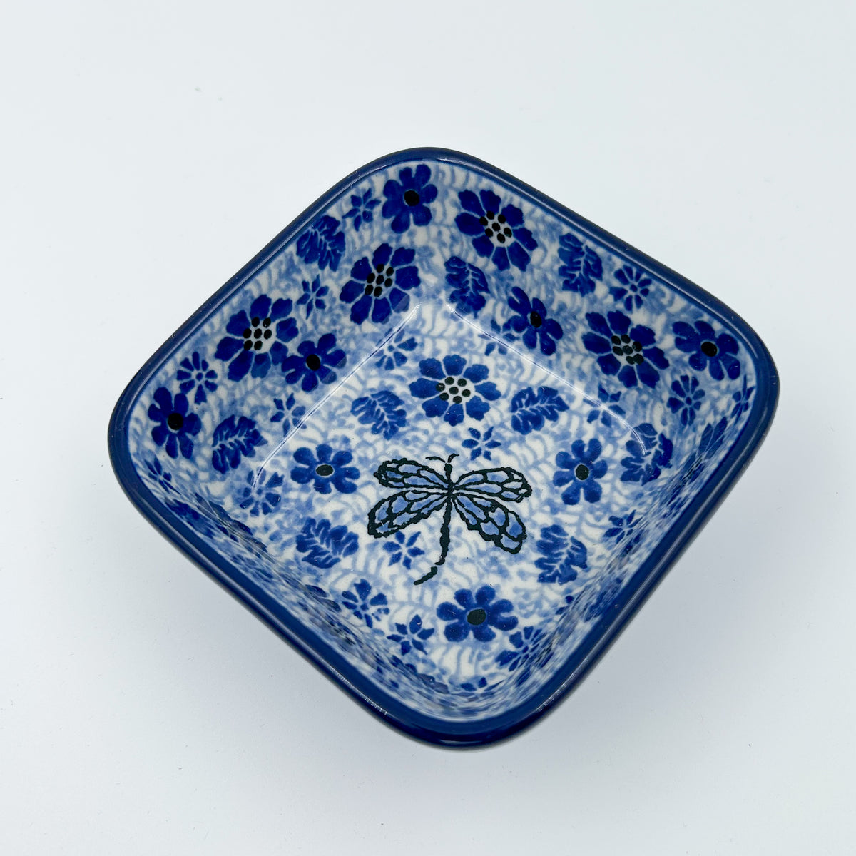 Misty Dragonfly square bowl, top-down angled view of dragonfly centered in blue floral pattern