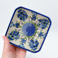 Blueberries square bowl held in hand, angled top-down view