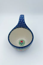Top-down view into Maraschino loop-handle bowl showing small red flower motif at center